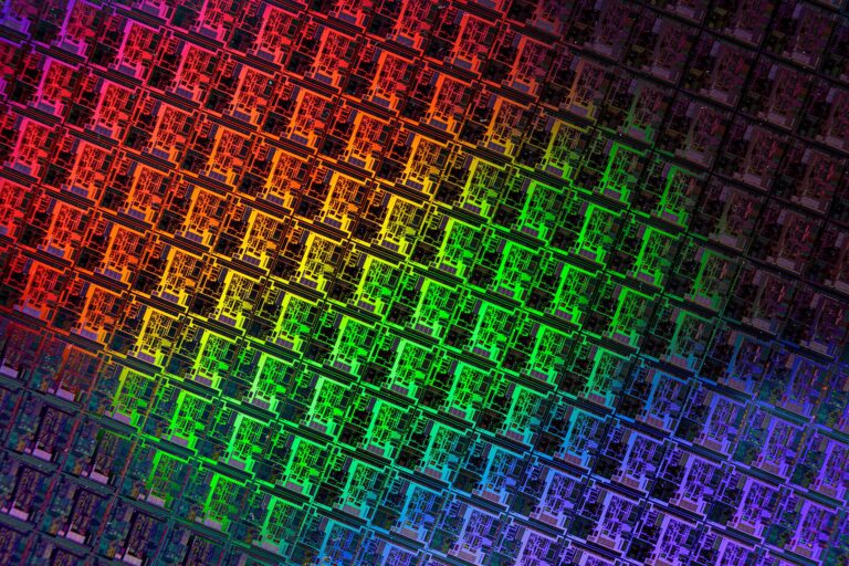 Close-up of a patterned silicon wafer with color gradients.