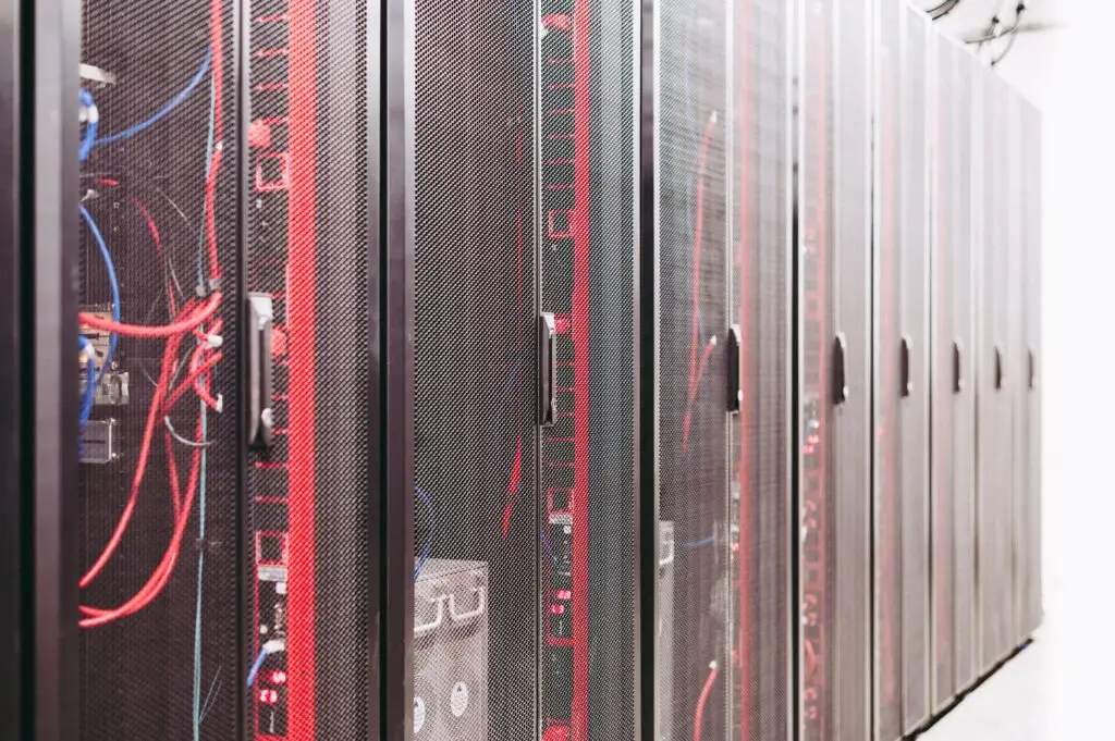 Data-center server racks with network and power cabling; illustrative infrastructure context, not a specific AI-rack deployment.