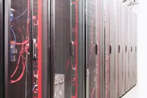 Data-center server racks with network and power cabling; illustrative infrastructure context, not a specific AI-rack deployment.