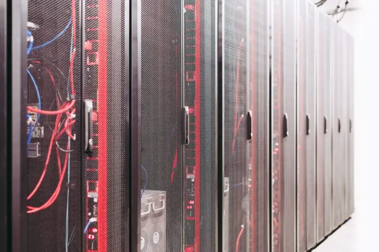 Data-center server racks with network and power cabling; illustrative infrastructure context, not a specific AI-rack deployment.