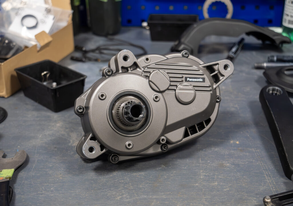 Prototype mid-mounted pedelec motor on a workbench.