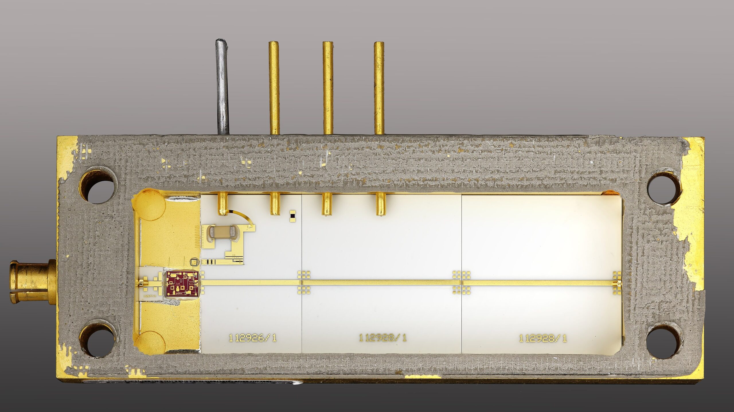 Opened amplifier module with a small wire-bonded chip inside a metal housing